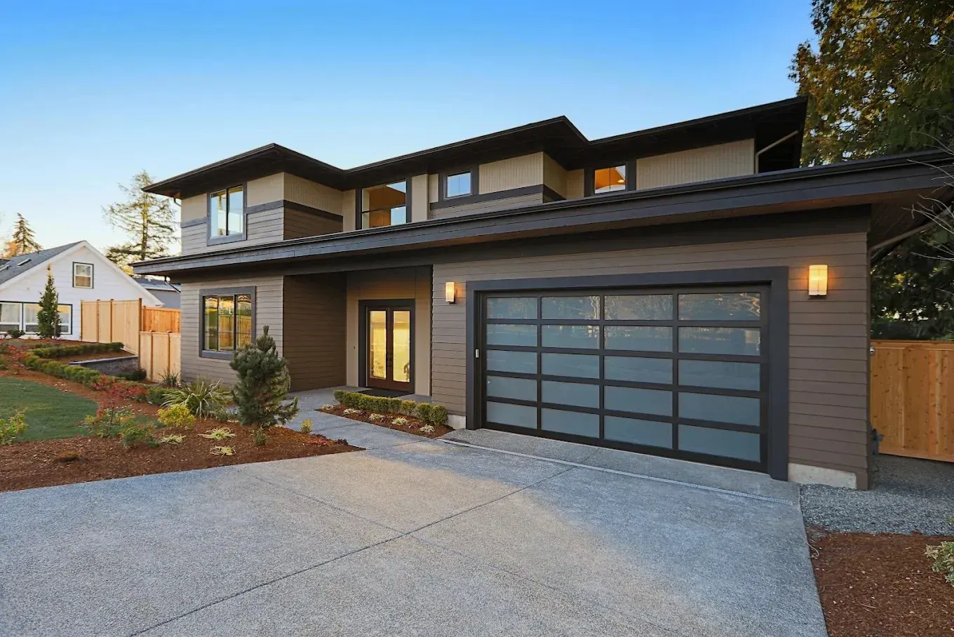 Modern glass garage door on a finished home exterior by Garagetex